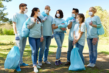Image showing volunteers in masks with garbage bags in park