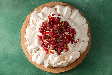 Image showing pavlova meringue cake with berries on wooden board