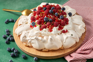 Image showing pavlova meringue cake with berries on wooden board