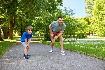 Image showing happy father and son compete in running at park