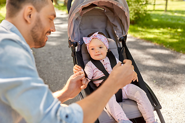 Image showing happy father with child in stroller at summer park