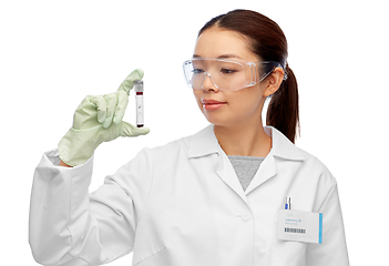 Image showing asian female doctor holding beaker with blood test