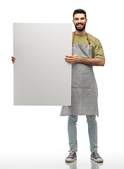 Image showing happy barman in apron holding empty white board