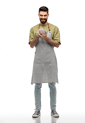 Image showing smiling waiter in apron taking notes to notepad