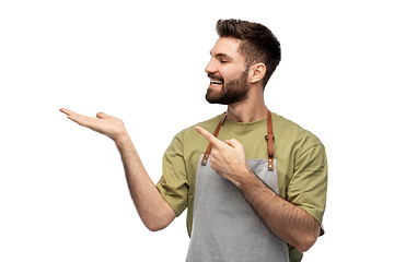 Image showing happy barman in apron holding something imaginary