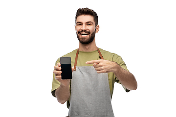 Image showing happy smiling barman in apron showing smartphone