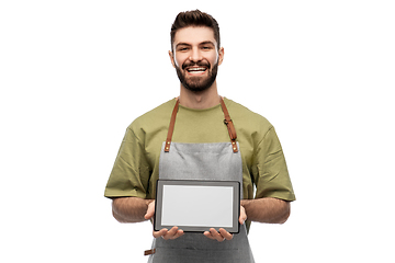 Image showing smiling waiter in apron showing tablet pc computer