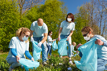 Image showing volunteers in masks with cleaning garbage at park