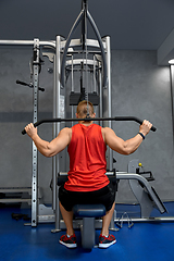 Image showing close up of man exercising on cable machine in gym