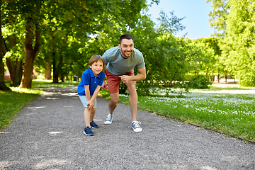 Image showing happy father and son compete in running at park