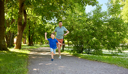 Image showing happy father and son compete in running at park