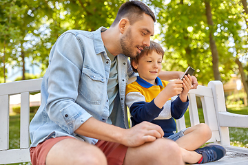 Image showing father and son with smartphone at park