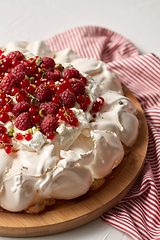 Image showing pavlova meringue cake with berries on wooden board