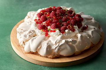 Image showing pavlova meringue cake with berries on wooden board