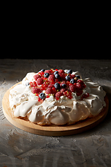 Image showing pavlova meringue cake with berries on wooden board