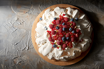 Image showing pavlova meringue cake with berries on wooden board