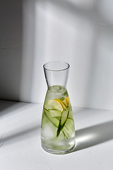 Image showing glass bottle of lemon water and cucumber on table