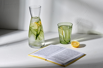 Image showing glass of water with lemon and cucumber and book