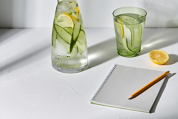 Image showing water with lemon and cucumber and notebook