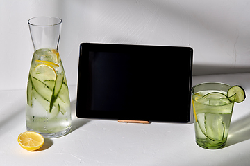 Image showing water with lemon and cucumber and tablet computer