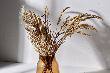 Image showing decorative dried flowers in brown glass vase