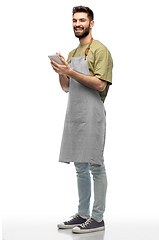 Image showing smiling waiter in apron taking notes to notepad