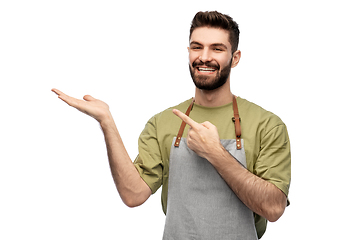 Image showing happy barman in apron holding something imaginary