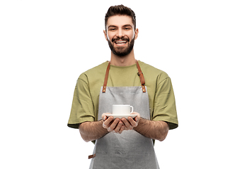 Image showing happy smiling waiter in apron with cup of coffee