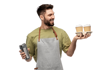 Image showing happy waiter with takeout coffee cups and tumbler