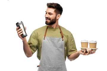 Image showing happy waiter with takeout coffee cups and tumbler