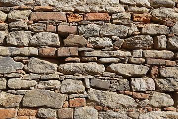 Image showing Texture of an old wall of stones and bricks lit by sunlight