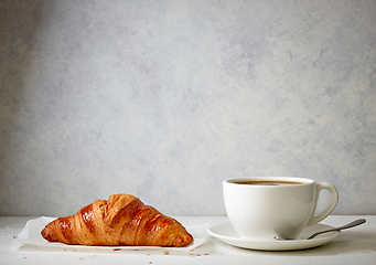 Image showing freshly baked croissant and cup of coffee