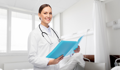 Image showing smiling female doctor with folder at hospital