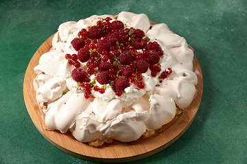 Image showing pavlova meringue cake with berries on wooden board