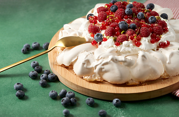 Image showing pavlova meringue cake with berries on wooden board