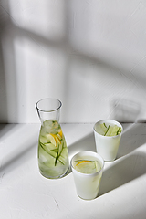 Image showing glasses with lemon water and cucumber on table