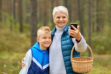 Image showing grandmother and grandson with baskets take selfie