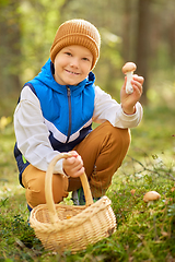 Image showing happy boy with basket picking mushrooms in forest