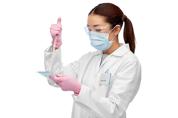 Image showing asian female scientist in mask working on vaccine