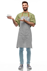 Image showing happy smiling waiter in apron with cup of coffee