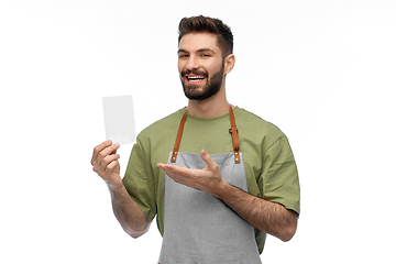 Image showing happy smiling barman in apron with bill