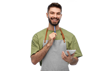 Image showing smiling waiter in apron with pen and notepad