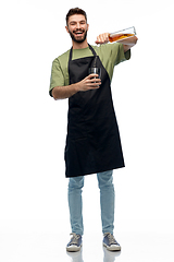 Image showing barman with bottle and shaker preparing drink