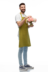 Image showing happy smiling male gardener with flowers in vase