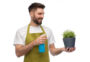 Image showing happy smiling male gardener moisturizing flower