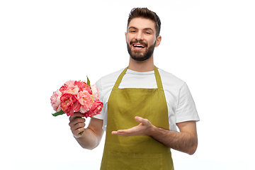 Image showing smiling male gardener with bunch of peony flowers