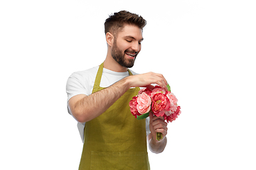 Image showing smiling male gardener with bunch of peony flowers