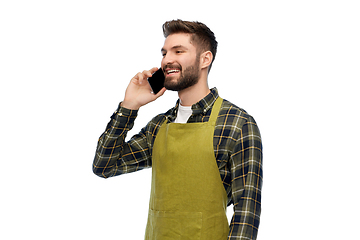 Image showing happy male gardener in apron calling on smartphone