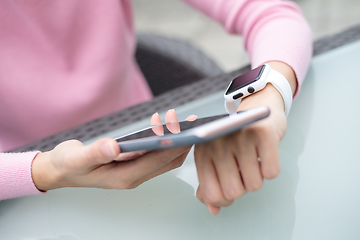 Image showing Woman using smart watch to connect with cellphone