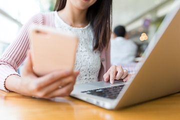 Image showing Woman using laptop computer and cellphone